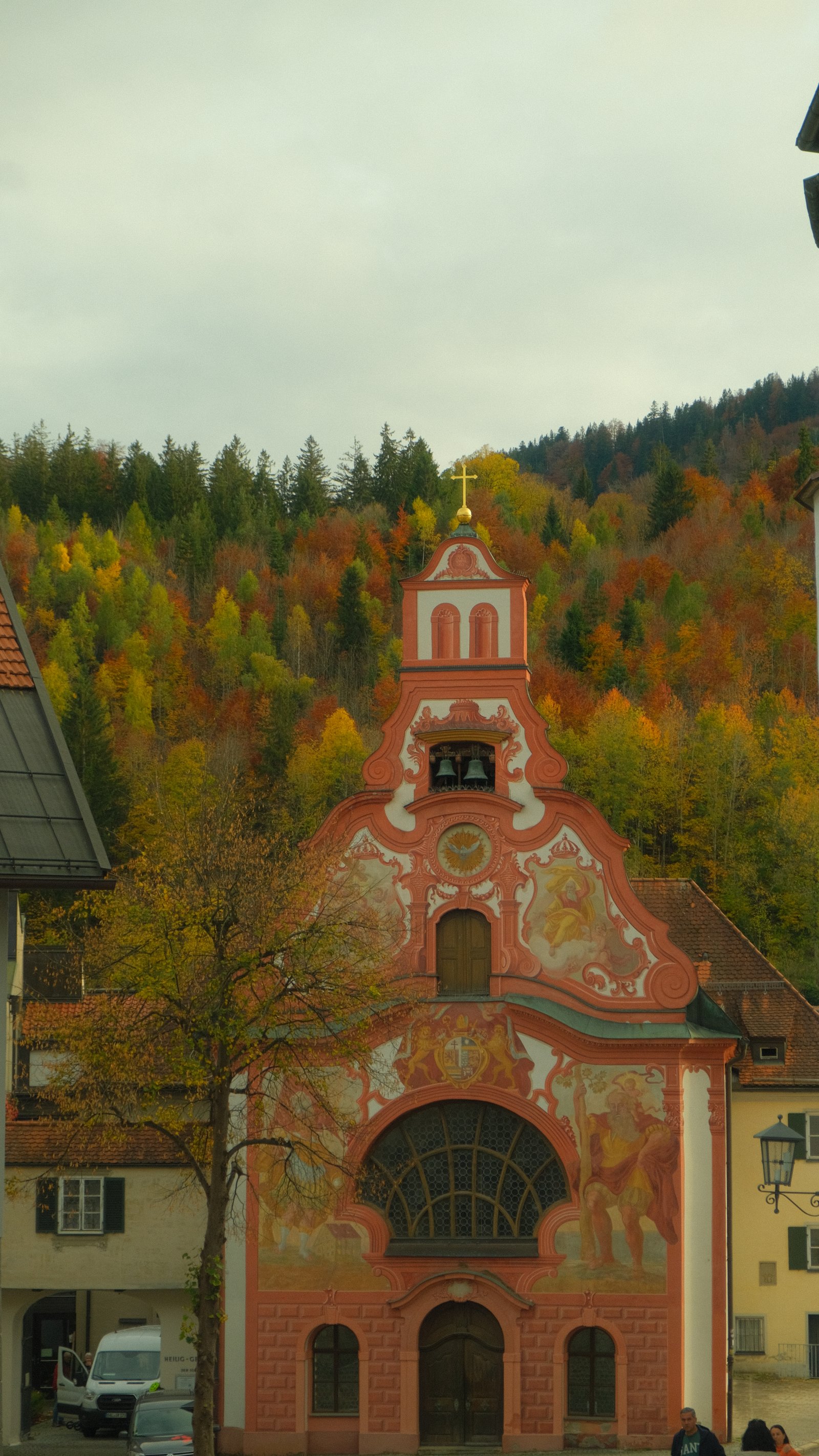 Red and white church among autumn trees in Fussen, Germany