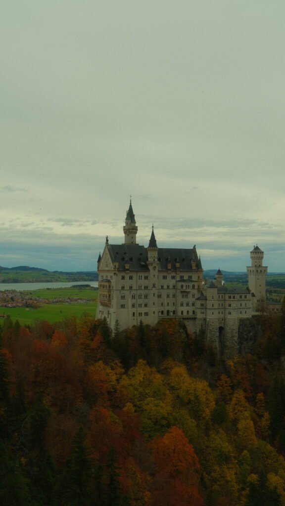 Neuschwanstein Castle perched above fall foliage in Füssen, Germany
