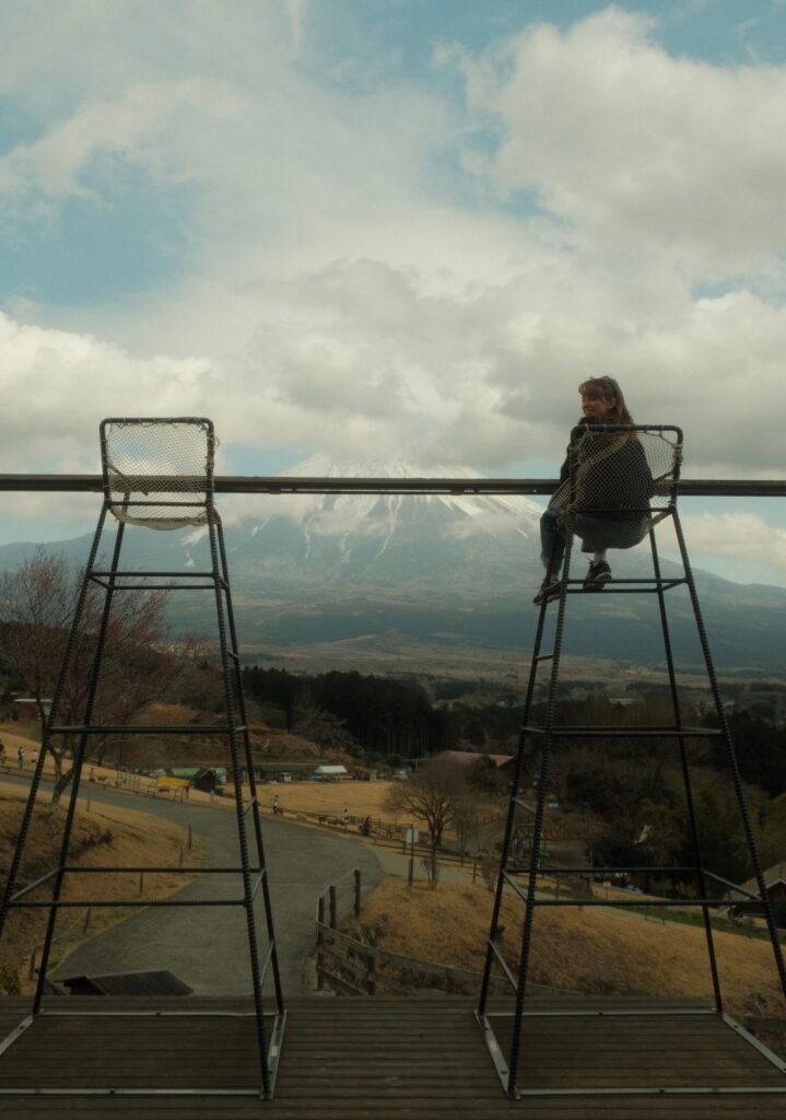 Woman sitting on large chair in front of Mount Fuji, Japan