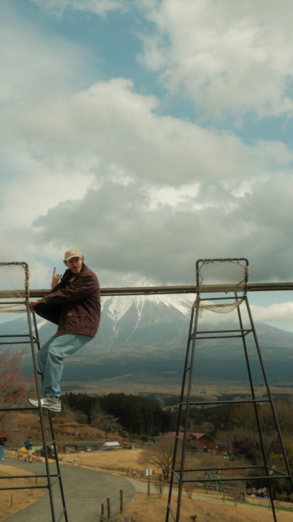 Man climbing large chair in front of Mount Fuji, Japan 