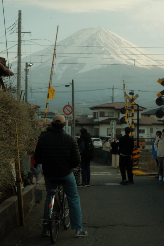 Man on bike on street with a view of Mount Fuji, Japan.