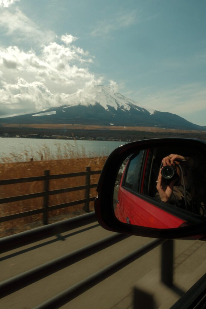 Car window overlooking a lake and Mount Fuji