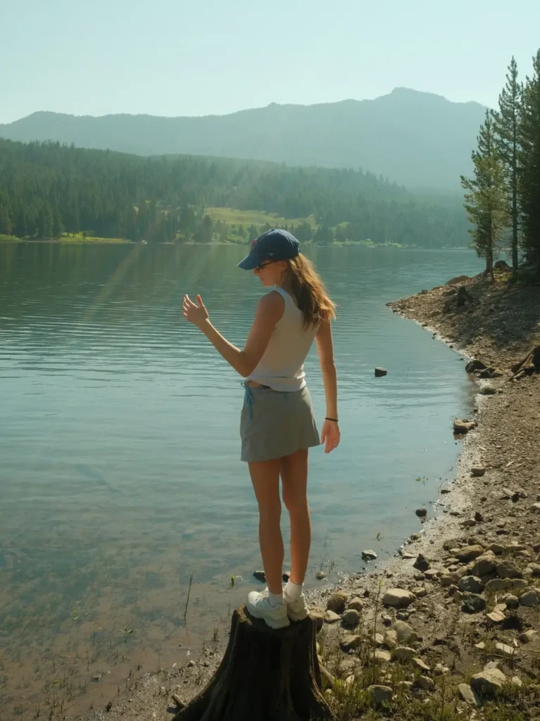 Girl standing on tree stump by the Hyalite Reservoir