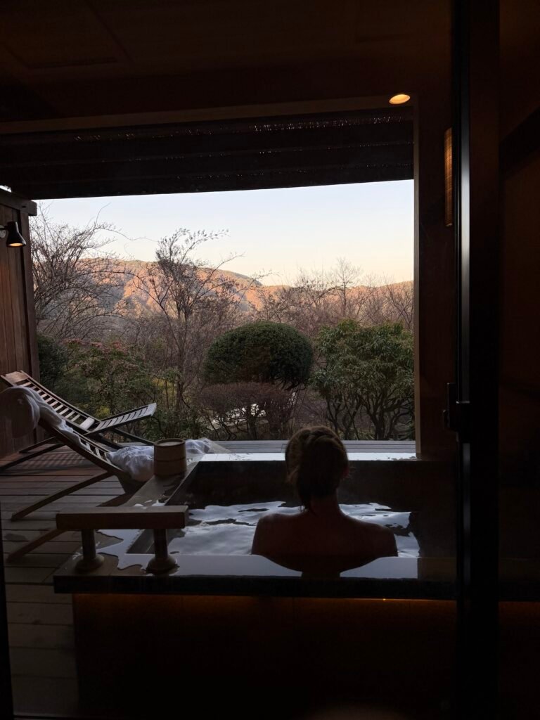 woman sitting gin onsen overlooking mountains at a ryokan in Hakone, Japan 