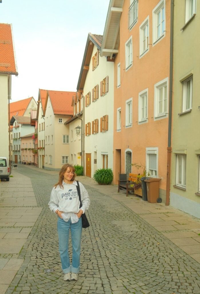 woman standing outside colorful buildings in Fussen, Germany