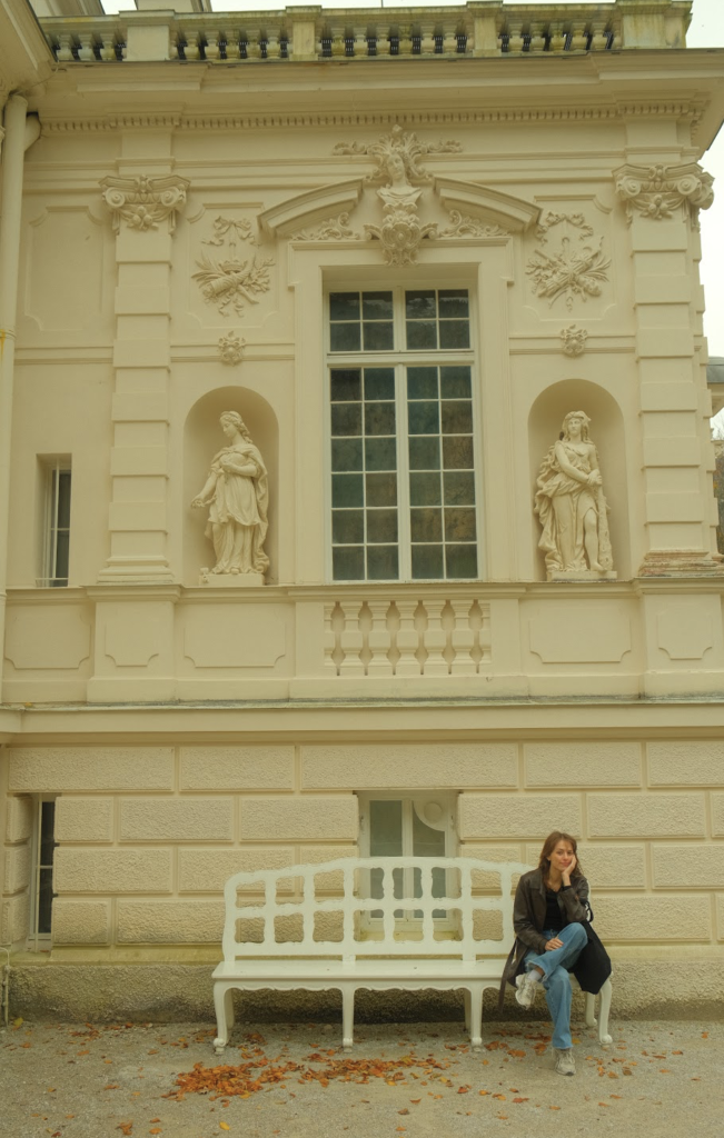 Girl sitting on bench outside Linderhof Palace in Germany